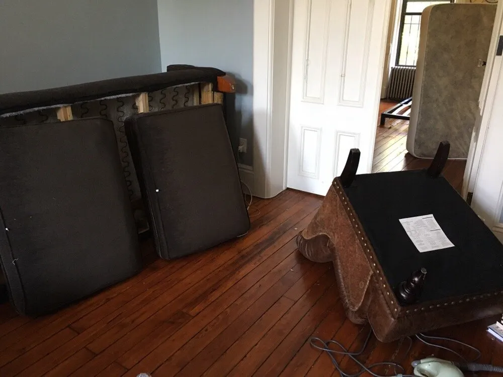 Furniture upended and cushions removed so a room can be treated and inspected